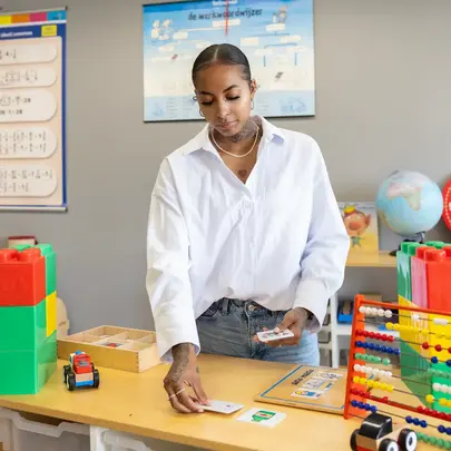 Student met educatief speelgoed en telraam op kinderopvang