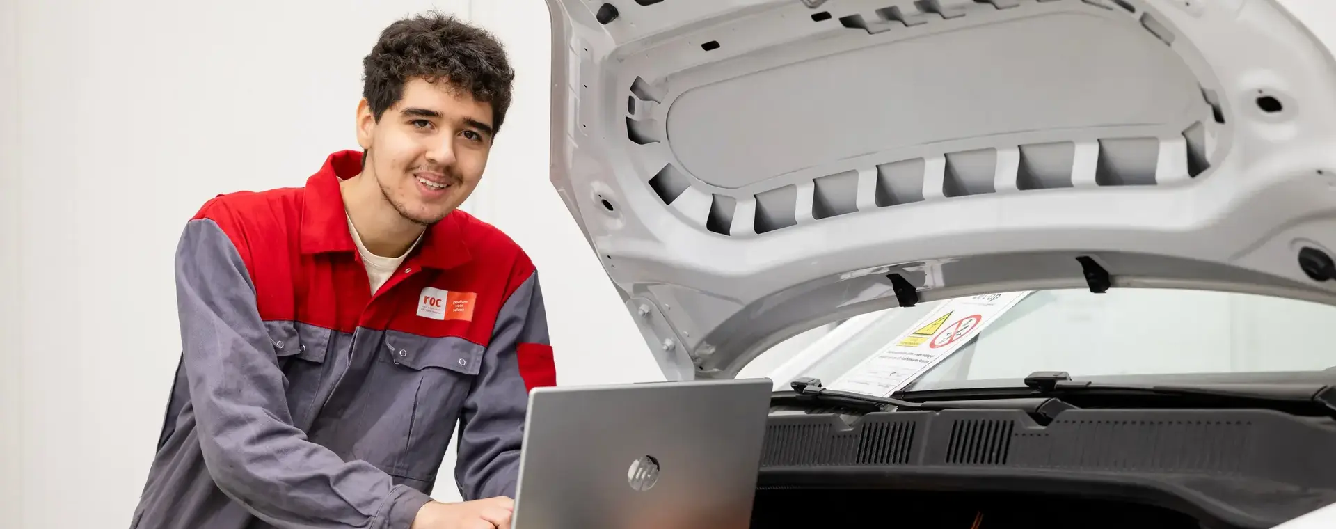 Student mobiliteitstechniek checkt motor auto met een laptop 