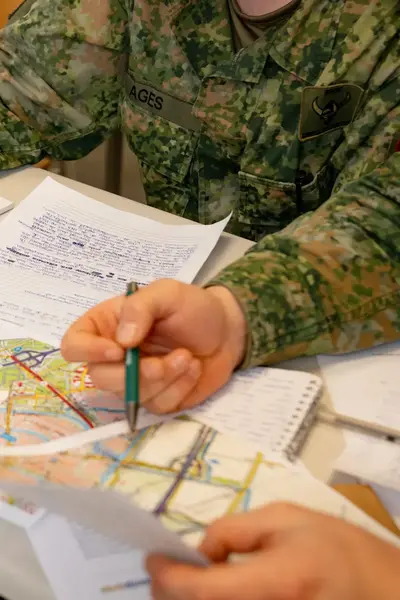 Studenten Veiligheidscollege in legeruniform bestuderen kaart en maken notities
