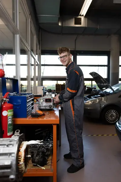 Automonteur staat aan werkbank in garage
