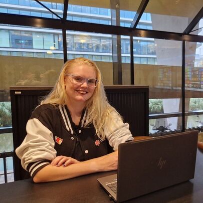 Student Cherona zit achter laptop in Glazen Huis op MBO College Zuidoost