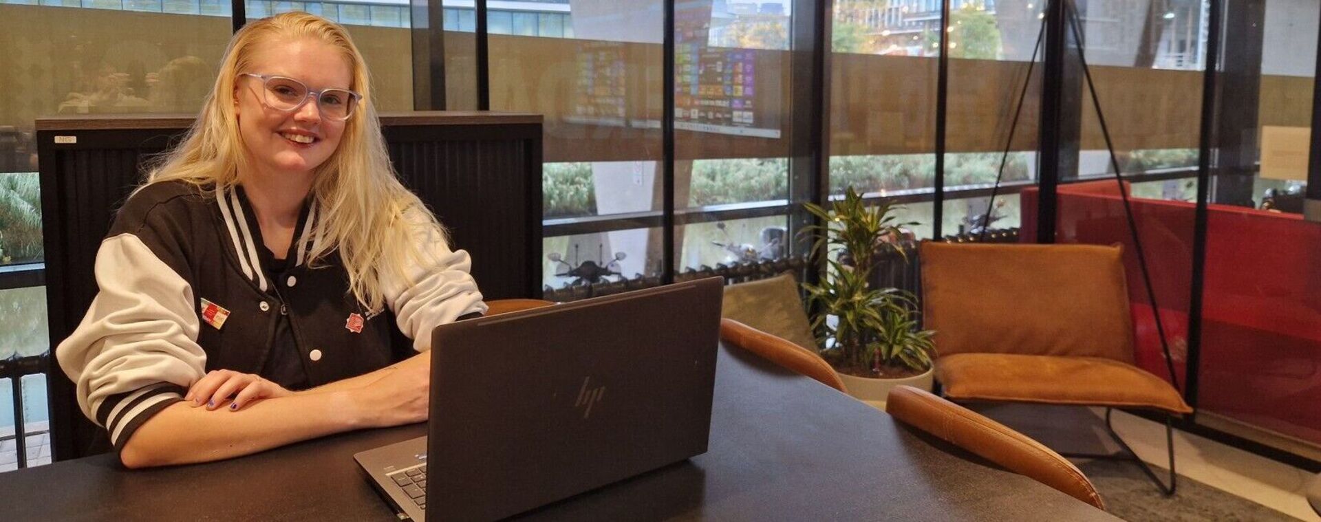 Student Cherona zit achter laptop in Glazen Huis op MBO College Zuidoost