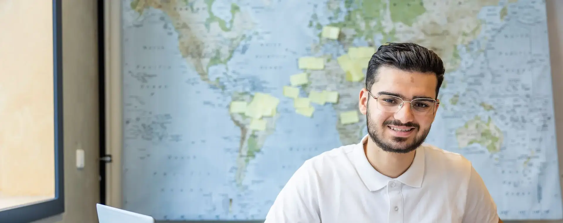 Student werkt aan zijn schoolopdracht met een laptop en rekenmachine.
