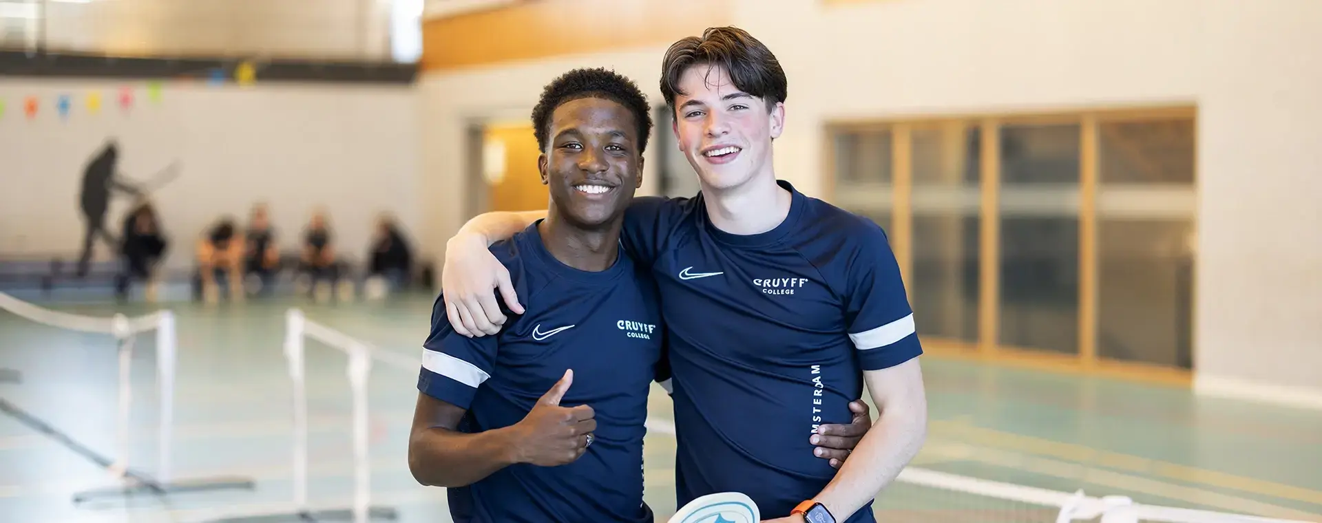 Twee sporters omarmd en duimpje omhoog
