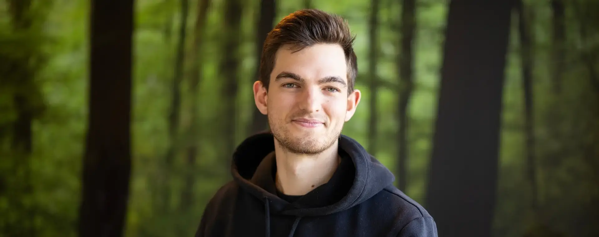 Zittende student poseert voor de foto.