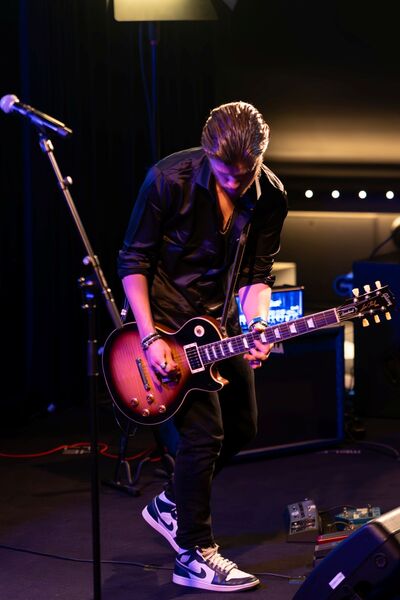 Student Muziek speelt gitaar op podium