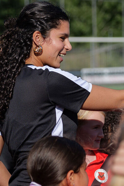 Beweegcoach Kinderen instrueert groepje kinderen op voetbalveld