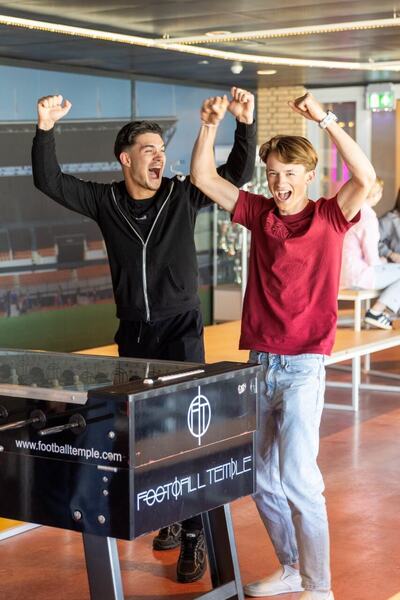 Twee studenten vieren hun overwinning met tafelvoetbal in kantine