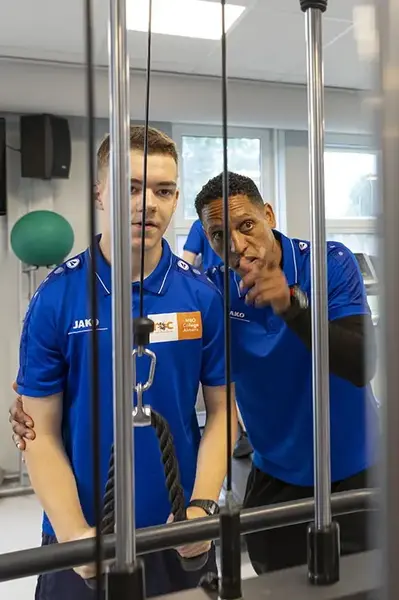 Coach geeft aanwijzingen aan gewichtheffer.