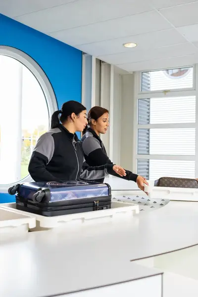 Studenten Luchthavenbeveiliger controleren bagage 