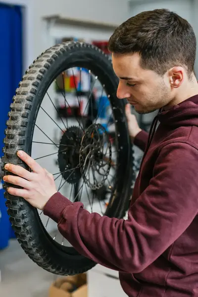Student monteert fietswiel in werkplaats.