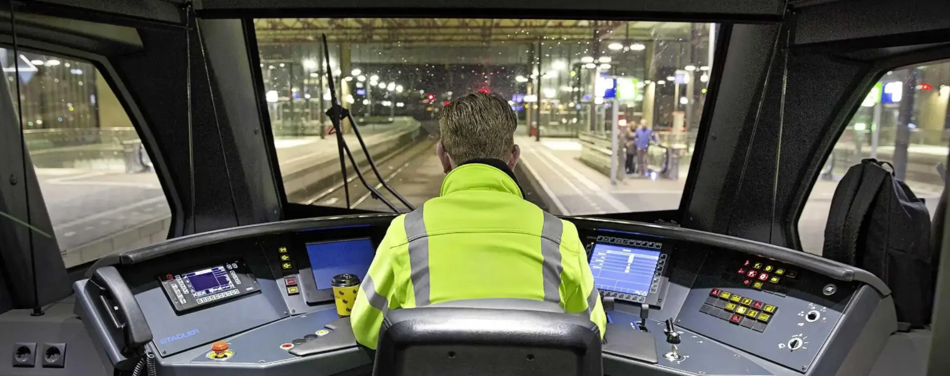 Machinist in treincabine op de rug gezien