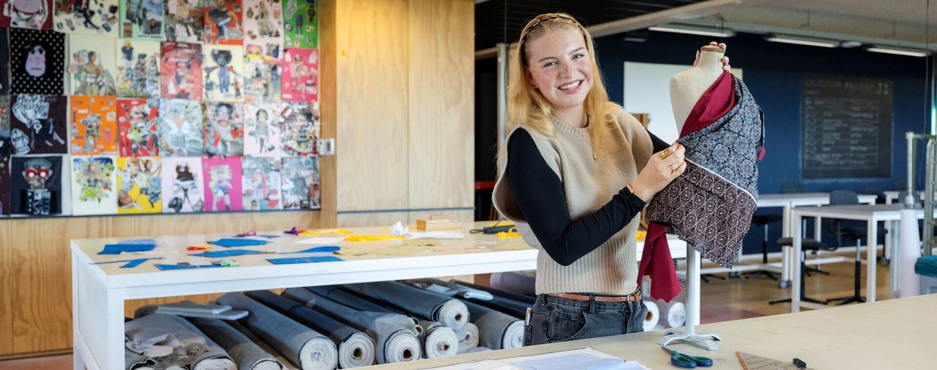 Fashion-student toont kledingstuk op paspop in modeatelier