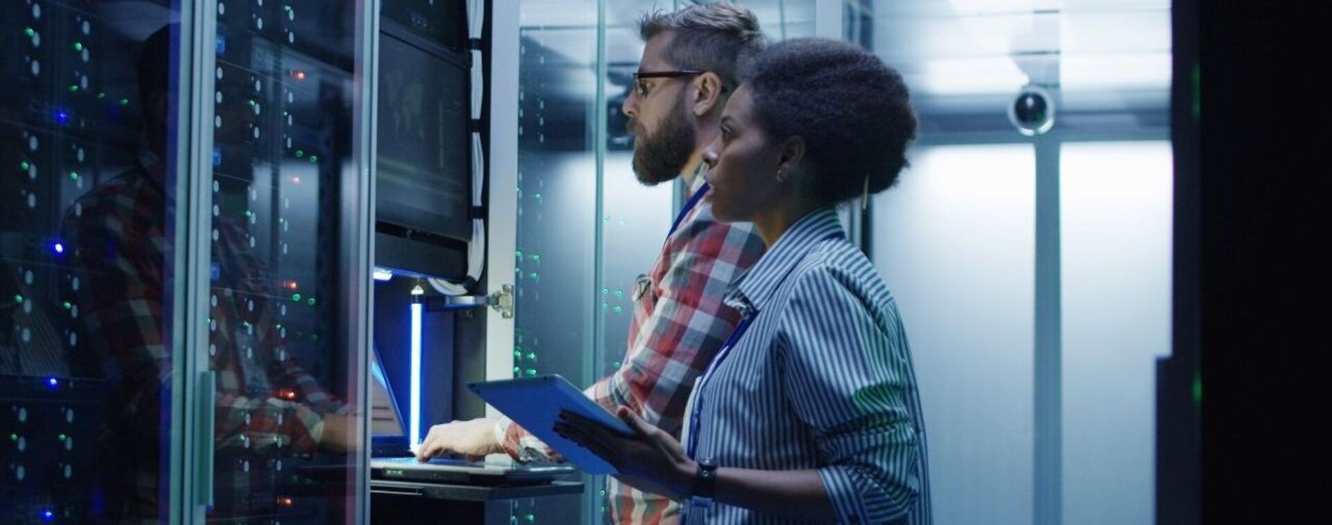 Man en vrouw controleren computers in datacenter