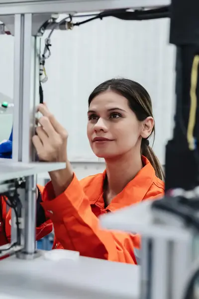 studenten mechatronica in oranje overalls bestuderen machine