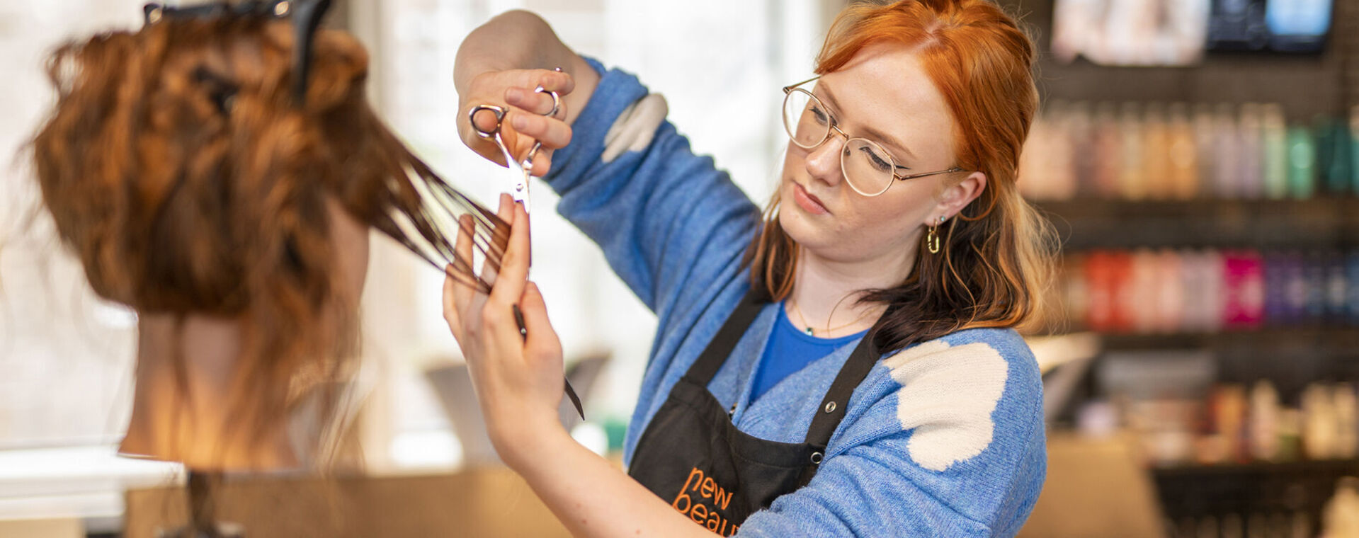 Roodharige dame knipt een oefenpop