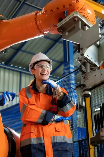 Lachende student in werkkleding tussen de machines. 