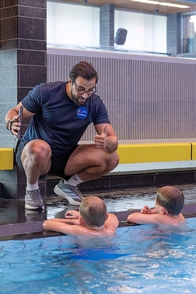Zweminstructeur instrueert kinderen in zwembad