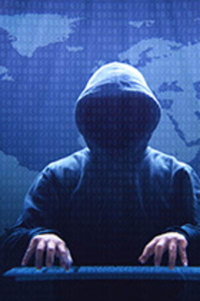 Anonieme persoon met hoodie achter toetsenbord