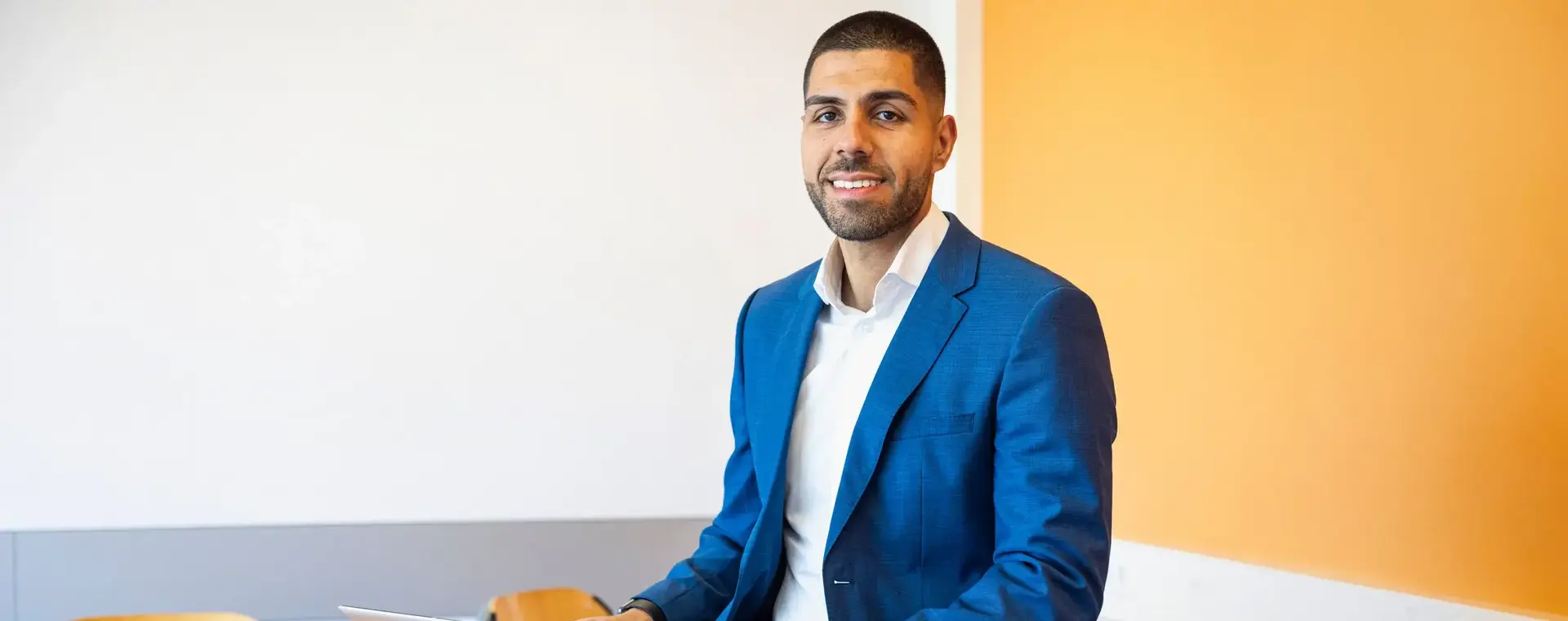 Man in pak zit in de klas met een laptop