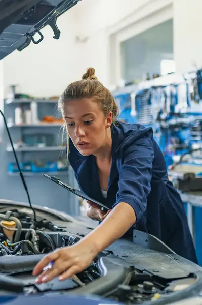 Automonteur controleert motor onder de motorkap