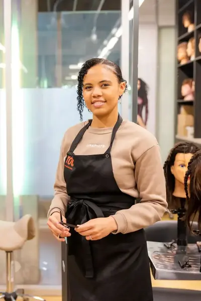 Student Haarverzorging poseert in salon met schort