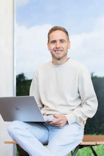 Man zit ontspannen met laptop op schoot