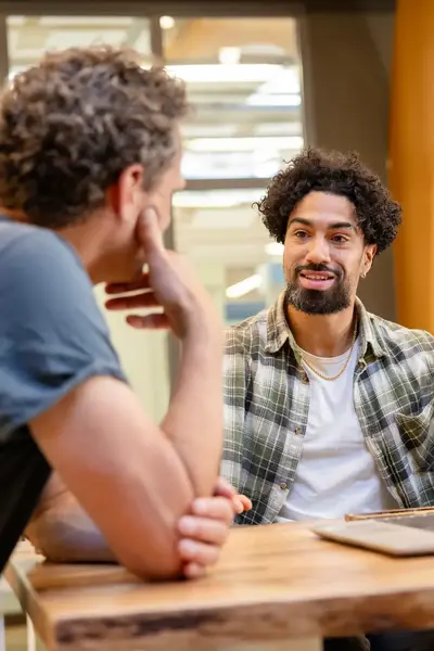 Twee studenten aan tafel achter een laptop