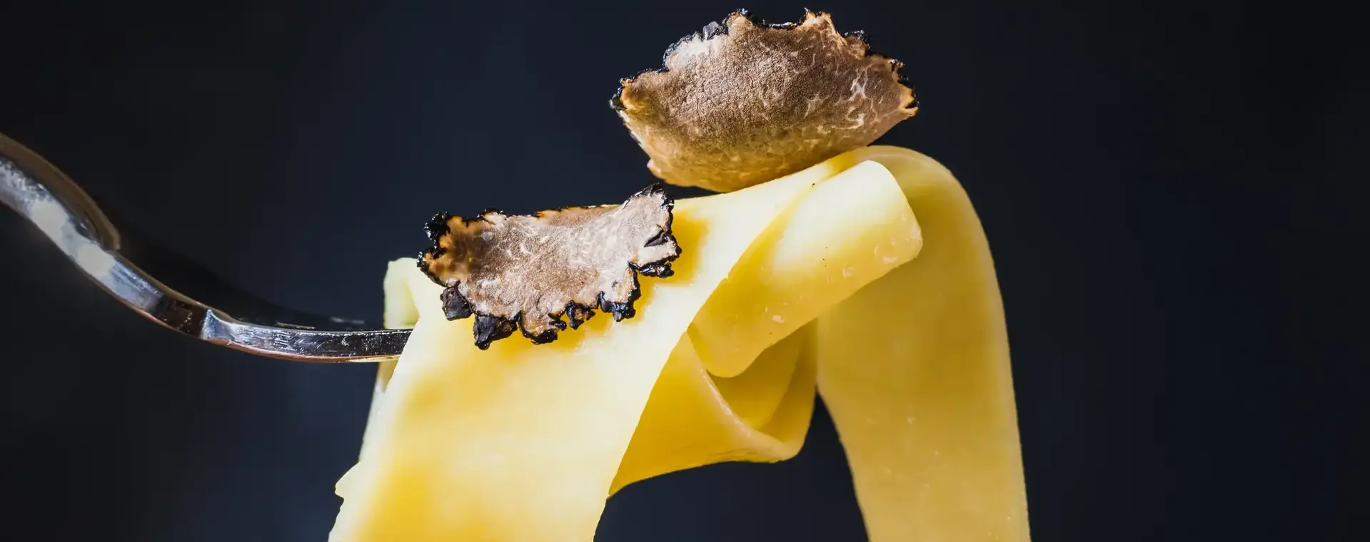Stukjes truffel op pasta op vork