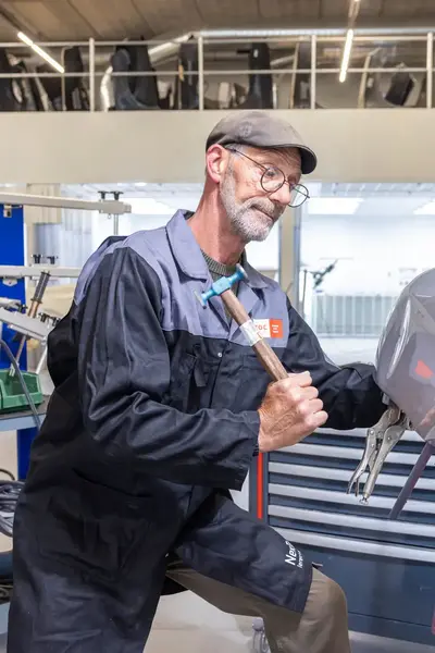 Automonteur met hamer herstelt schade aan carrosserie