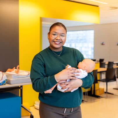 Gespecialiseerd Pedagogisch Medewerker student Daniela Isabel met babypop in praktijklokaal