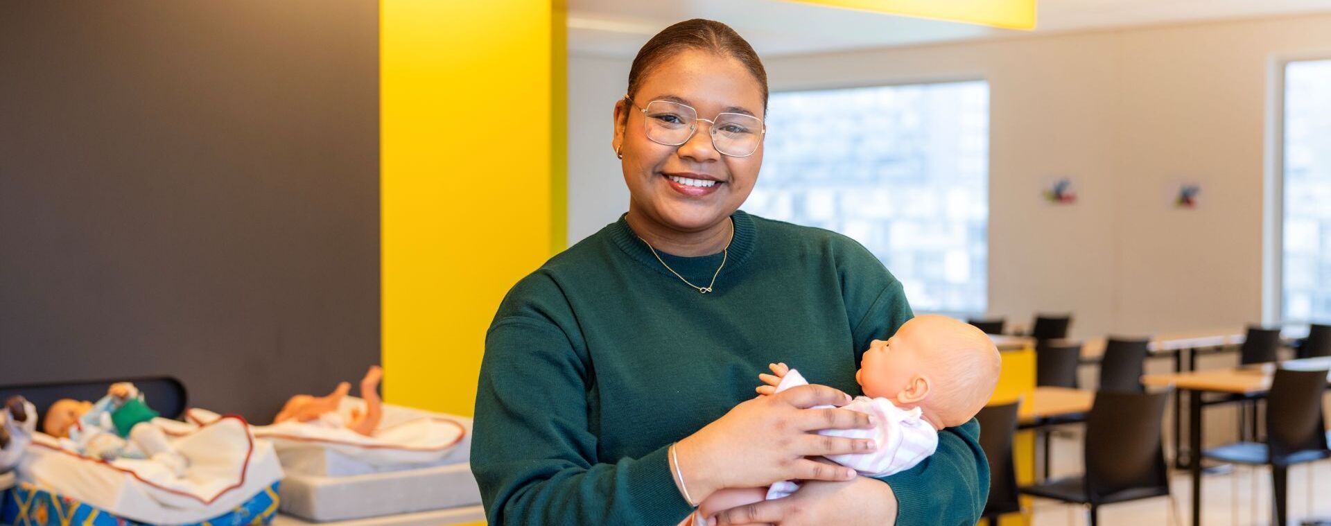 Gespecialiseerd Pedagogisch Medewerker student Daniela Isabel met babypop in praktijklokaal