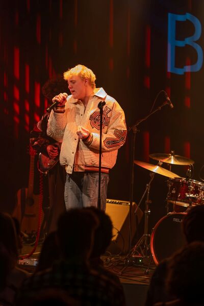 Student Muziek zingt op podium tijdens optreden