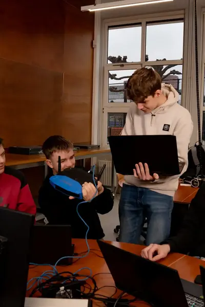Groep jongens bezig met wifi aan te sluiten op een laptop.