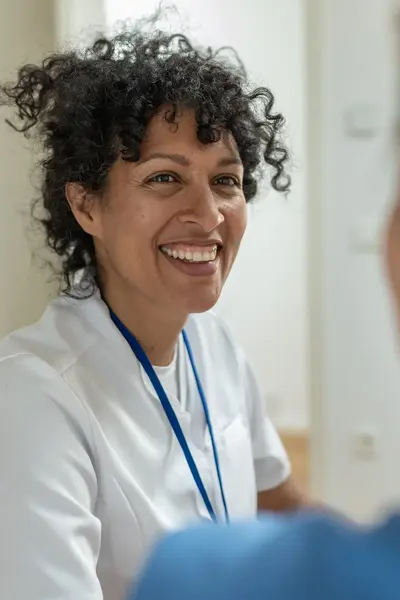 Lachende vrouw met op de voorgrond de achterkant van een vrouw.