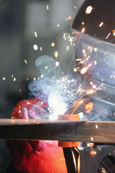 Lasser met gezichtsbescherming last metalen buis