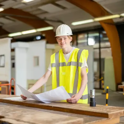 Student Bouwkunde met bouwtekening in praktijklokaal 