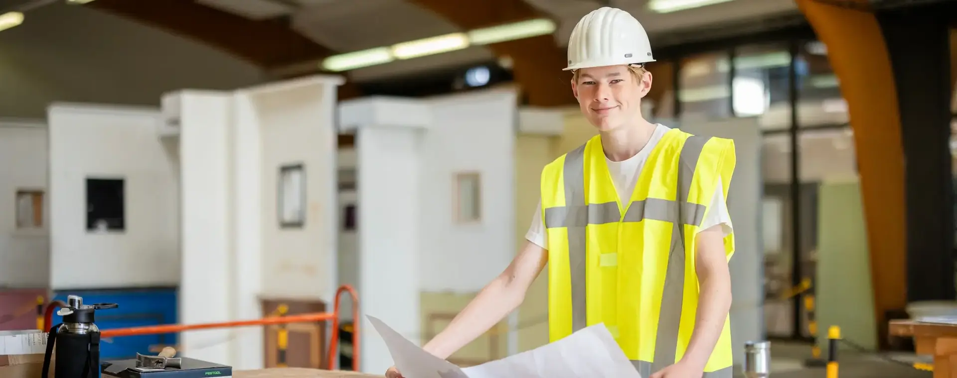 Student Bouwkunde met bouwtekening in praktijklokaal 