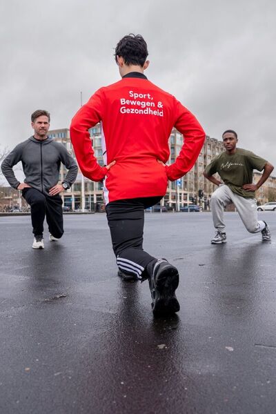 Sportstudenten trainen buiten in de regen op straat