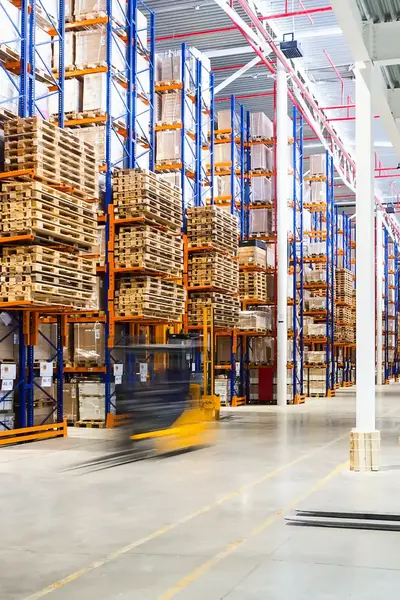 Gigantisch magazijn met twee gele vorkheftrucks.