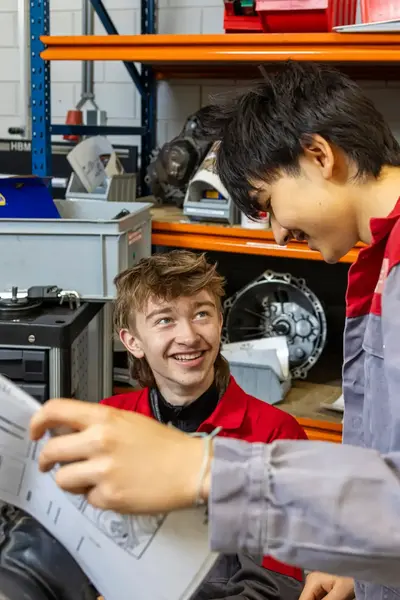 Twee studenten in garage te midden van wieldoppen