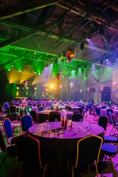 Evenementenlocatie vol horecameubilair en uitgelicht podium