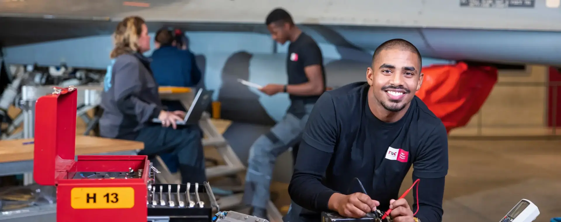 Student met gereedschap bij vliegtuig