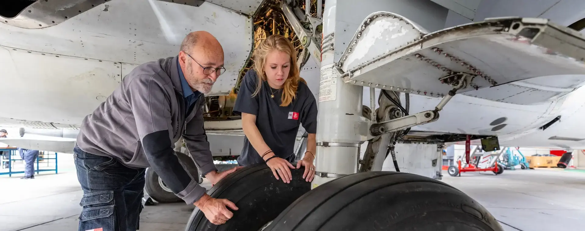 Student en docent checken landingsgestel vliegtuig