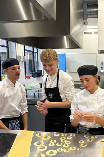 Vier koksleerlingen maken ravioli in de keuken