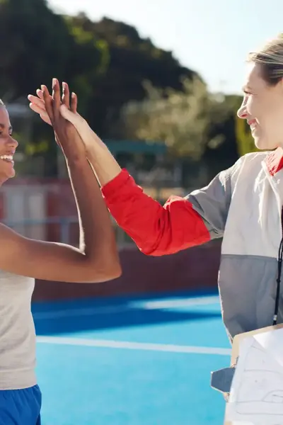 Sporter en coach geven elkaar een high-five