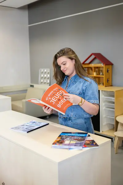 Student Pedagogiek leest in jeugdboek in leslokaal