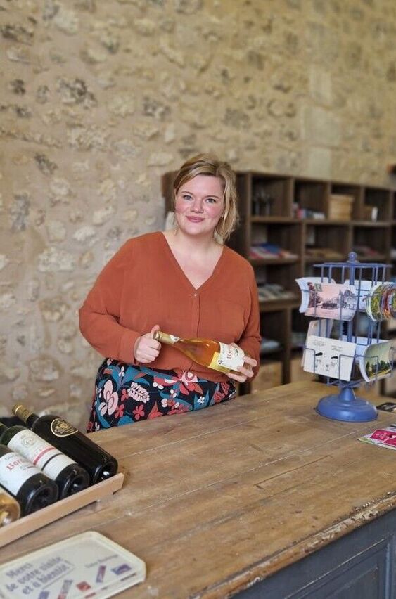 Dame presenteert wijnfles in chateau