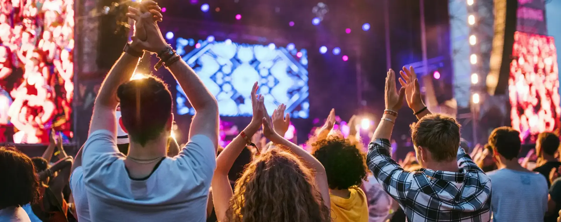 Een grote groep klappende mensen voor een podium bij een groot event