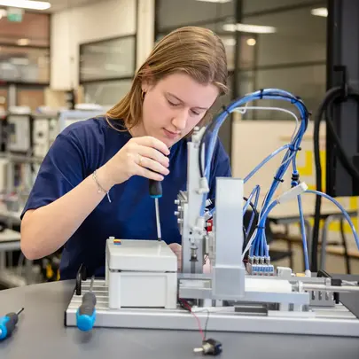 Student inspecteert apparaat in praktijklokaal